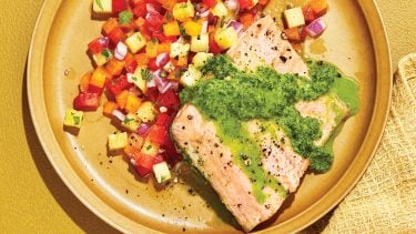 Baked trout with green sauce and pineapple-pepper salso on light brown plate.
