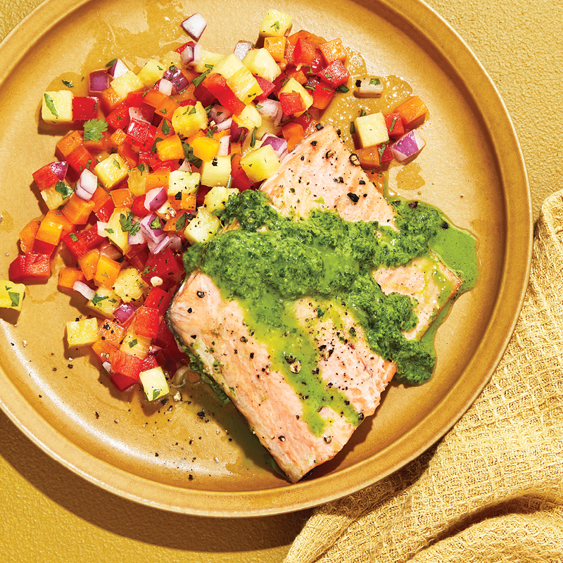Trout with green sauce and pineapple-pepper salso on light brown plate.