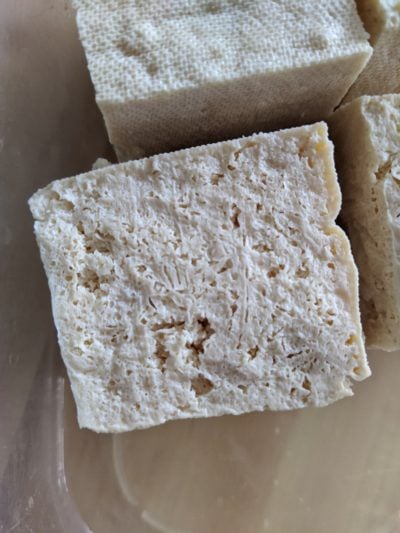 closeup of thawed tofu, with plenty of holes