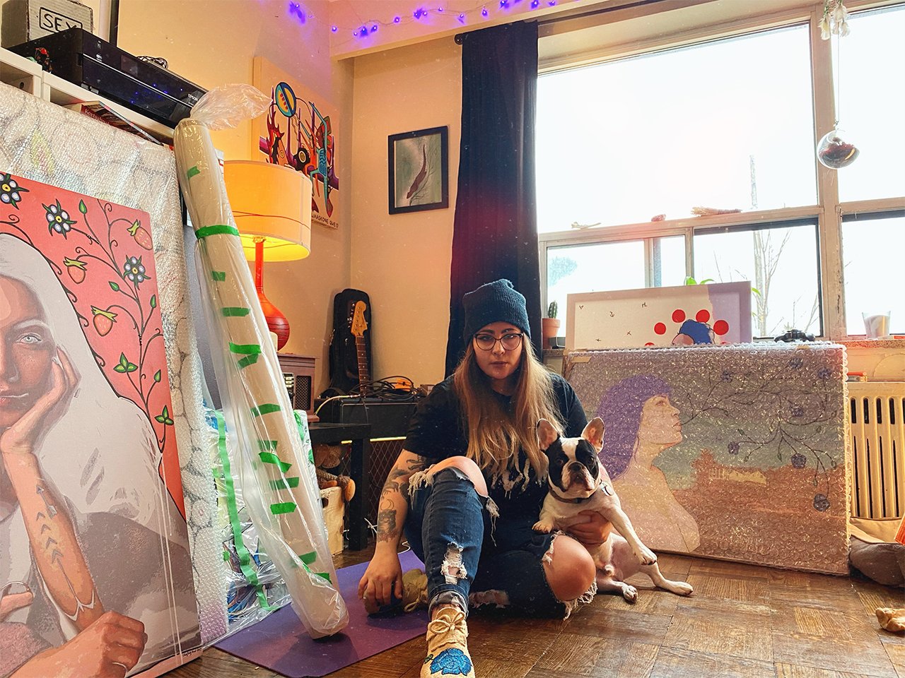 Canadian artist Chief Lady Bird sitting in front of several of her pieces for an article on female artists in Canada.