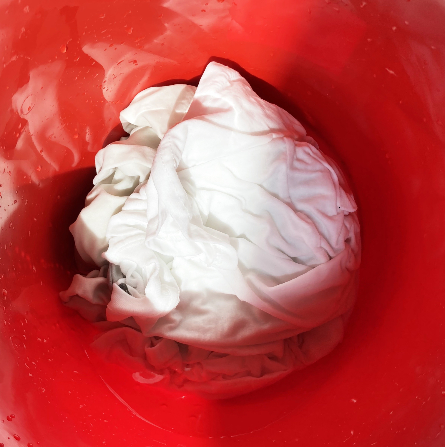 A white t-shirt in a bucket ready to be tie-dyed