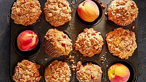 Peach cobbler muffins and peaches in a muffin pan