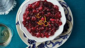 Homemade cranberry sauce in small white serving bowl on a set Thanksgiving table