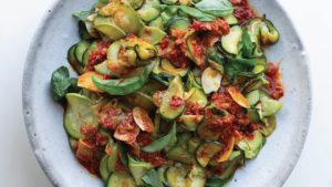 Ottolenghi's super soft zucchini with harissa and lemon on speckled white plate