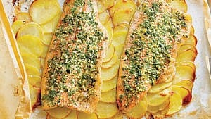 Baked rainbow trout fillets with tarragon and parsley herb mix, and thin potato slices