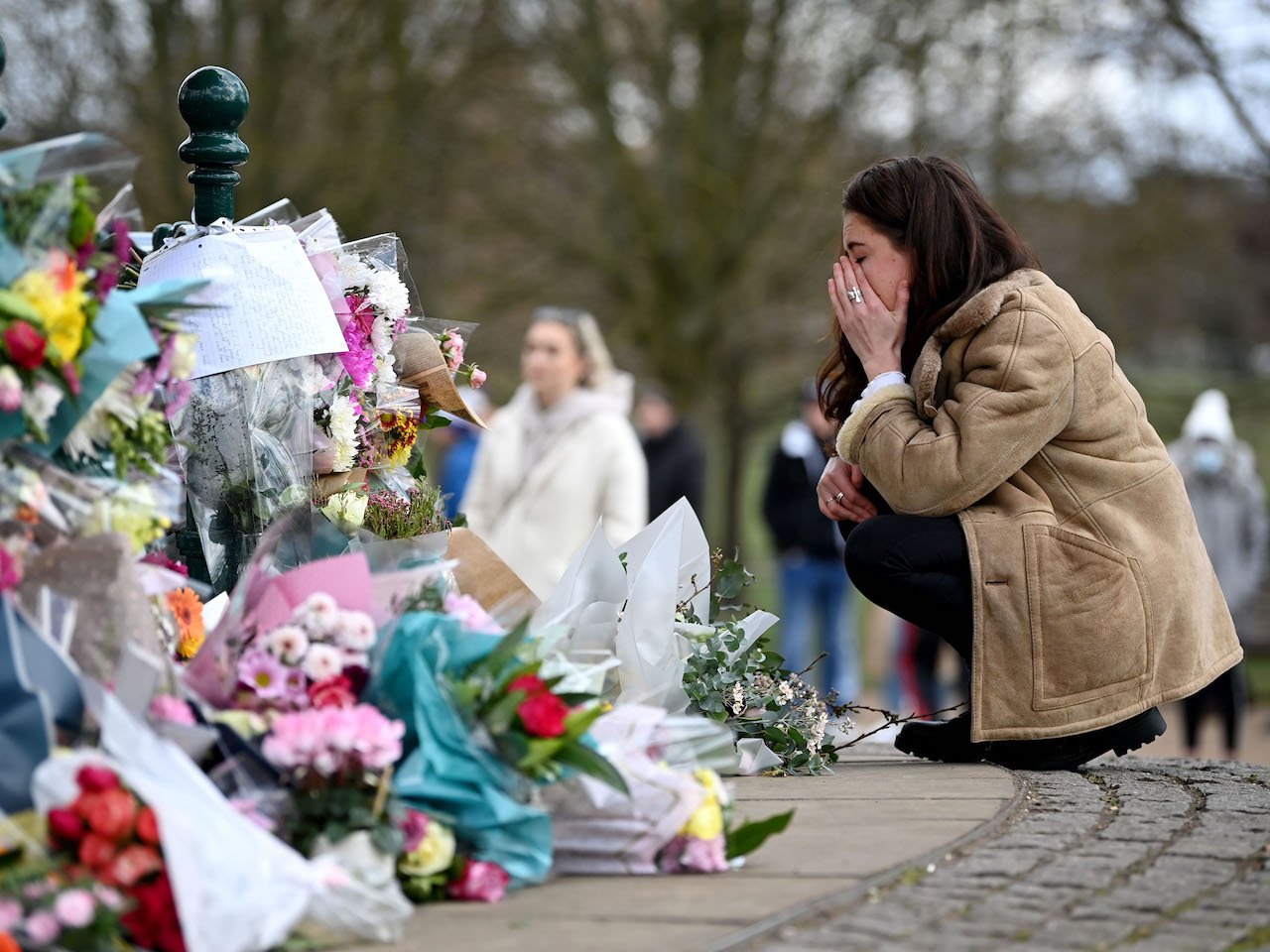 A woman reacts as she lays flowers in tribute to Sarah Everard at the bandstand on Clapham Common on March 13, 2021 in London, United Kingdom. Vigils are being held across the United Kingdom in memory of Sarah Everard. Yesterday, the Police confirmed that the remains of Ms Everard were found in a woodland area in Ashford, a week after she went missing as she walked home from visiting a friend in Clapham. Metropolitan Police Officer Wayne Couzens has been charged with her kidnap and murder.