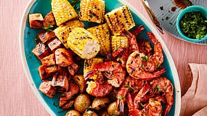 Grilled shrimp, corn and sausage in a pan