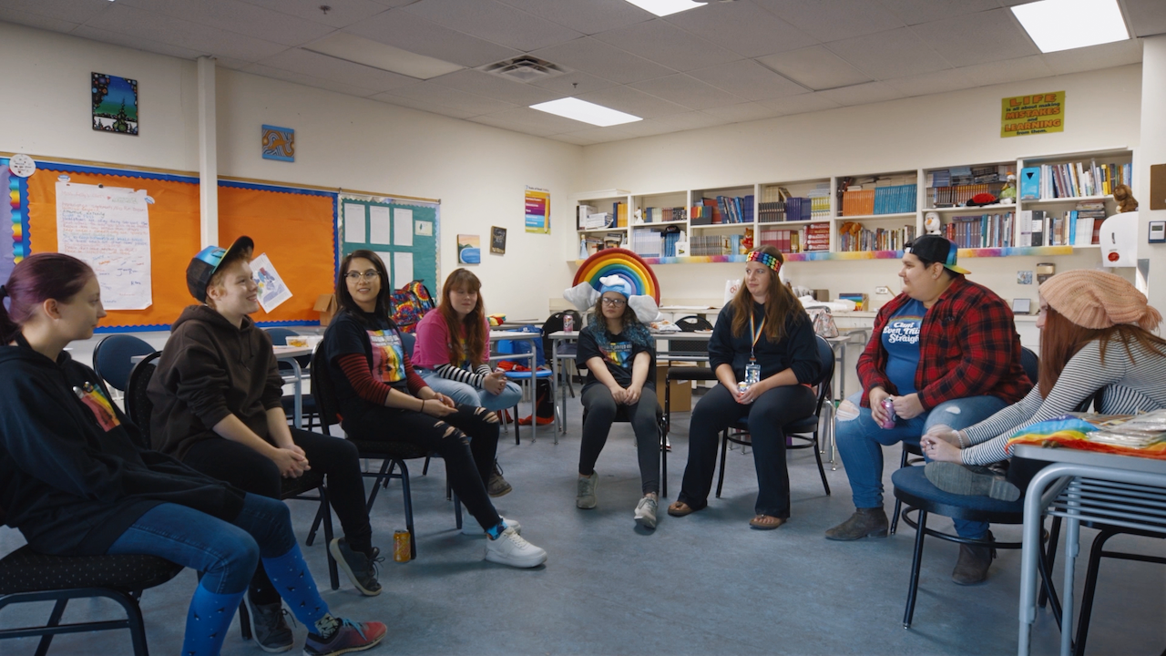A photo of a group of LGBTQ2S+ people in a meeting