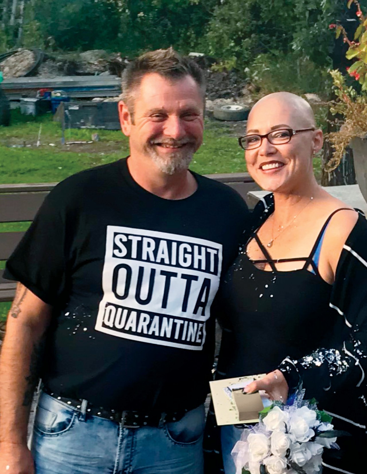 A photo of a middle-aged man wearing a T-shirt that says Straight Outta Quarantine and a woman in a black tank top