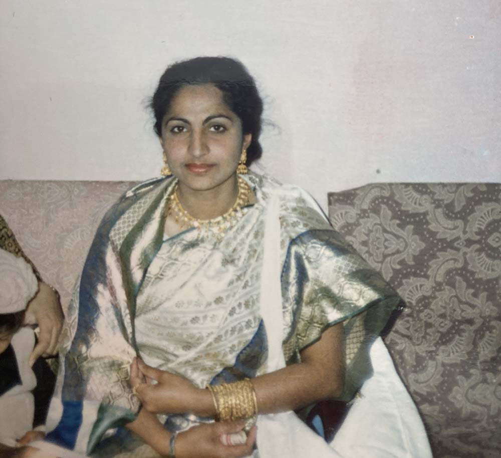 The author's mother, wearing a gold necklace, earrings and bracelets, in an old photo