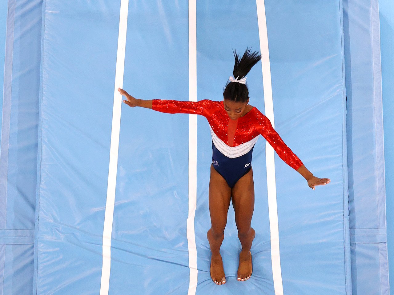 A photo of Simon Biles regaining her balance after a competition at the Tokyo Games. 