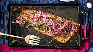 A za'atar-roasted-salmon sits on a black plate.