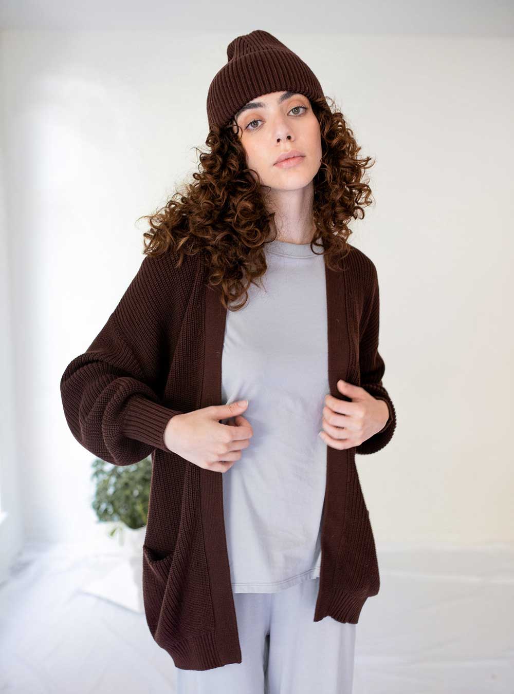 A model wearing a brown knit cardigan from Paper Label.