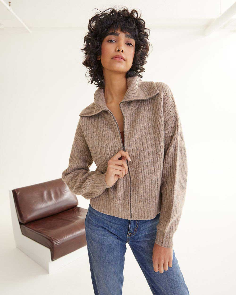 A model wearing an oatmeal zip-up ribbed cardigan from Reitmans.