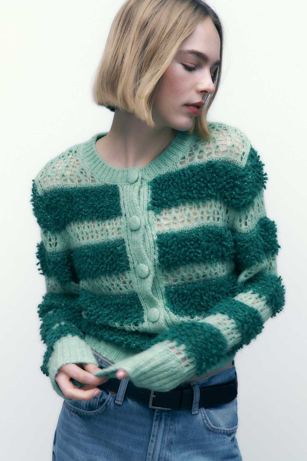 A model seen from the waist up wearing a mint green and teal mohair-blend green cardigan from Zara.