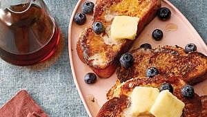 A plate of french toast with butter squares on top.