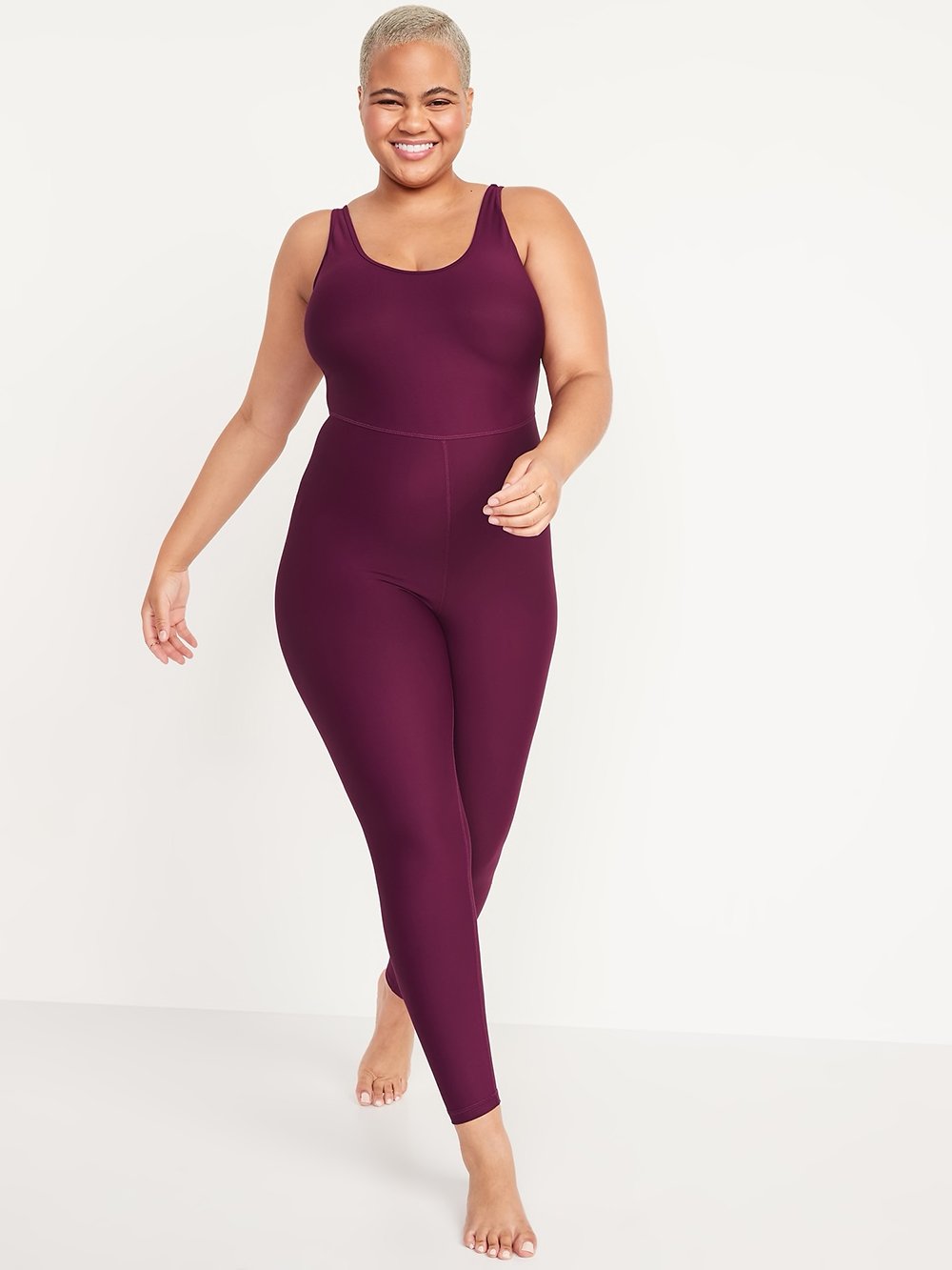 A model wearing a one-piece purple workout bodysuit from Old Navy.