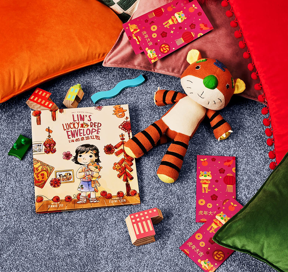 A stuffed tiger and a children's book sit on a grey, carpeted background.