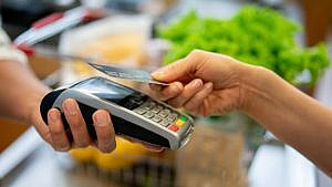 Close up of unrecognizable customer doing a contactless payment at the supermarket