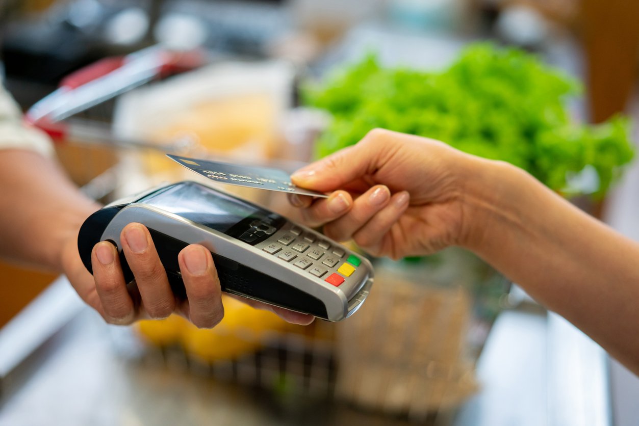 Close up of unrecognizable customer doing a contactless payment at the supermarket
