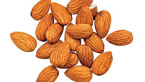 A handful of whole almonds against a white background