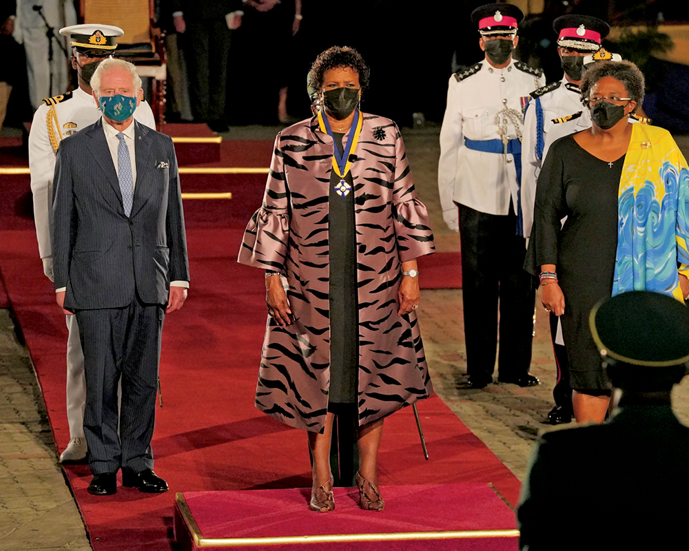 Prince Charles, in a mask, stands alongside Barbadian president Sandra Mason and Prime Minister Mia Mottley. 
