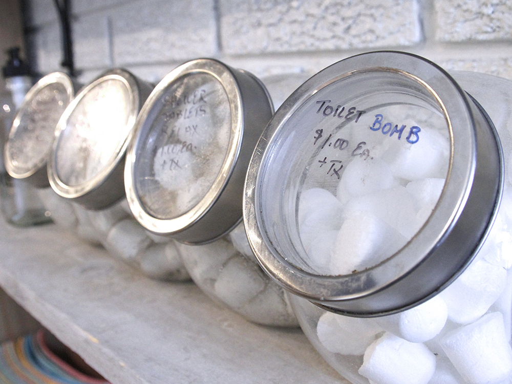 Toilet bombs in clear glass jar with silver lid.