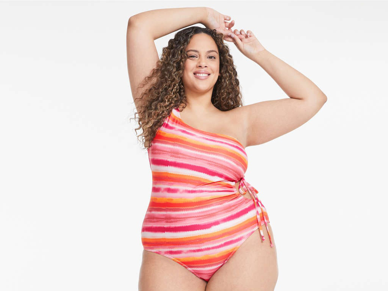 A plus-size model wearing a one-shoulder colourful Joe Fresh swimsuit.