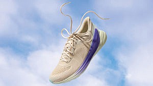 One of Lululemon's Blissfeel running shoes floating on a background of a blue sky with white clouds. The shoe's colours are Light Ivory/Charged Indigo/Delicate Mint