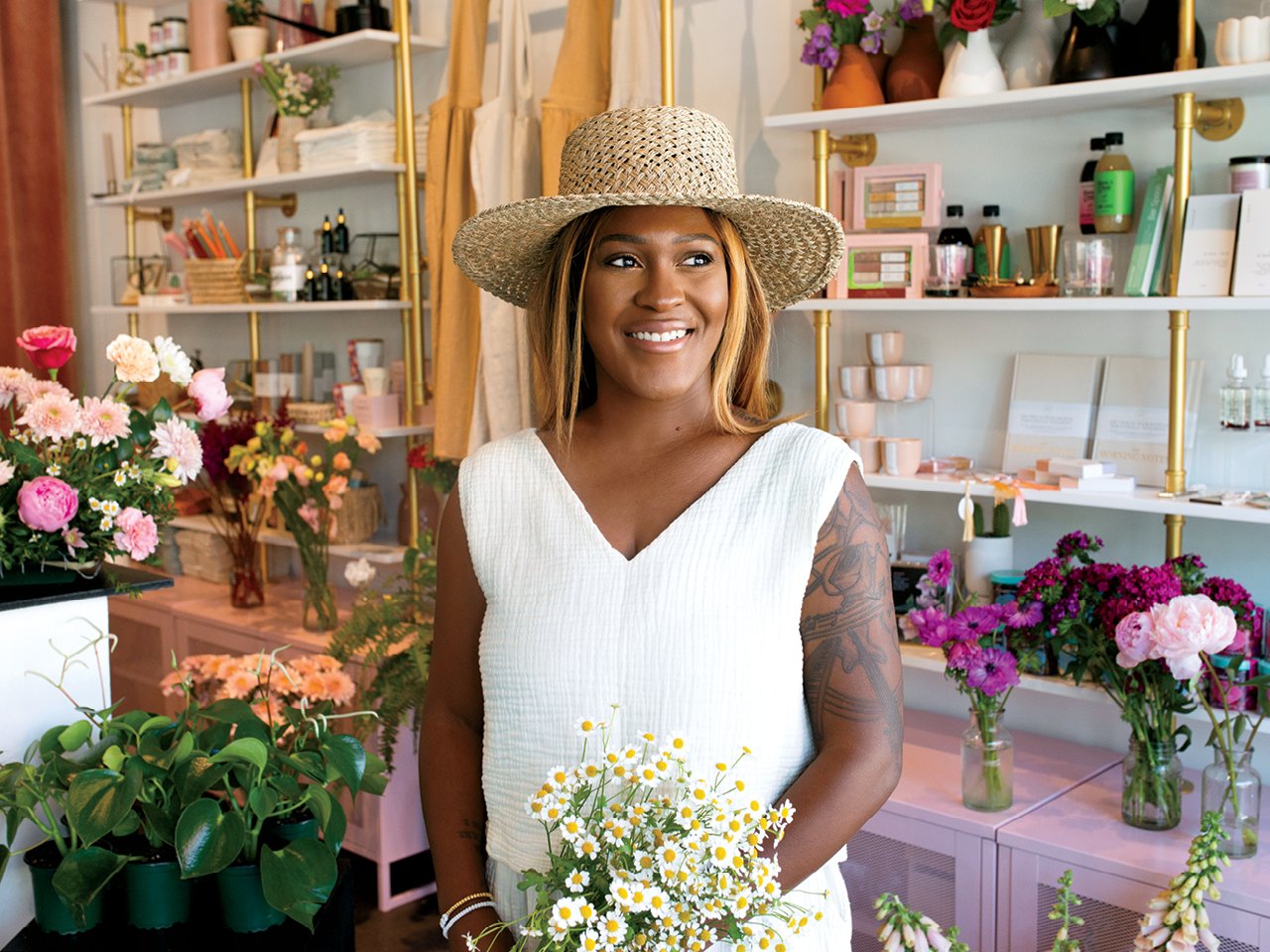 A photo of a woman in a white dress standing in a florist shop