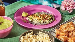 A pink plate with spiced fish with cumin and lime on it