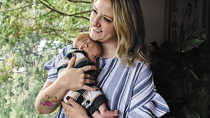 Emilee Rausch cradles baby Simon at their Saskatoon home. Simon was conceived with the help of a donor sourced on a Facebook group that connects Canadians hoping to become parents with sperm donors.