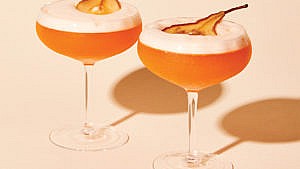Two bartlett sour cocktails topped with slices of dried pear