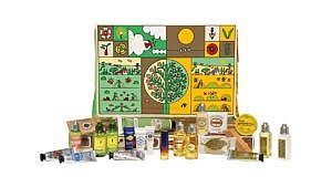 A box of L’Occitane advent calendar featuring a graphic illustration, surrounded by travel-sized mini beauty products.