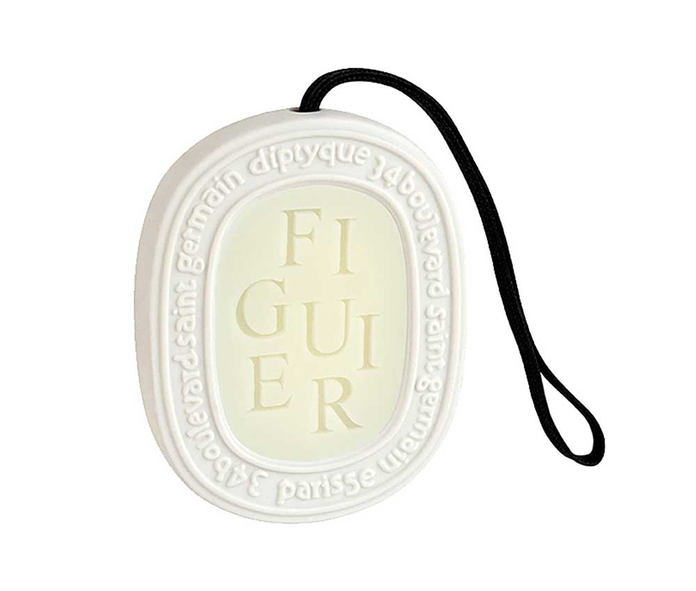A white scented ceramic Diptyque medallion scented with Figuier.