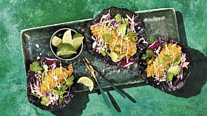 Three cabbage leaf fish tacos topped with jalapeno, avocado, and mayonnaise
