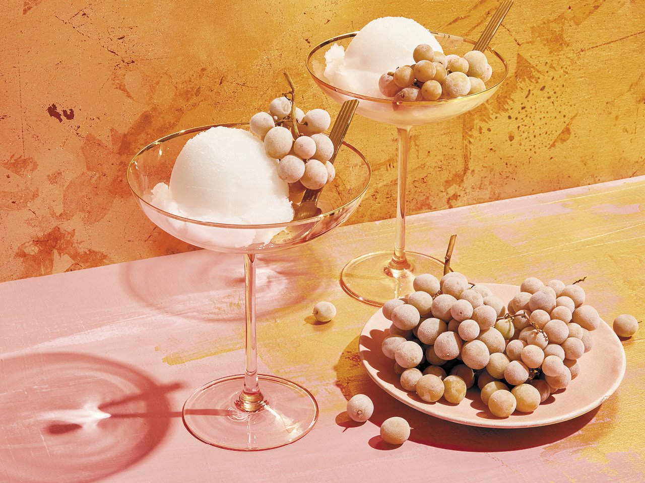 Two glasses of champagne sorbet, served alongside champagne grapes