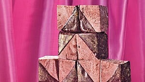 Eight snickerdoodle marshmallows stacked against a pink backdrop