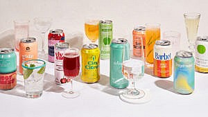 a series of cans of sparkling water next to half-filled glasses
