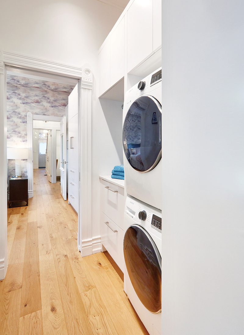 A hallway with a stacked washer and dryer