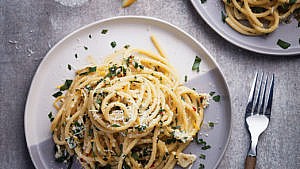 Easy Lemon Pasta recipe with herbs and cheese on a flat white plate