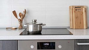 An induction stove with a stainless steel pot on top of it