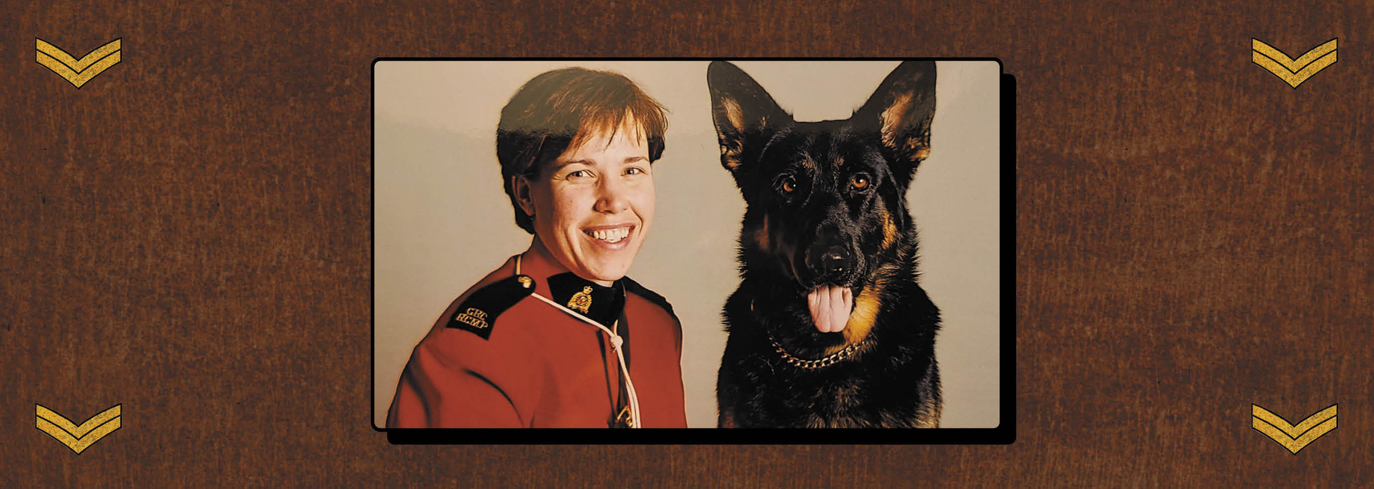 Judi Watt poses in her red RCMP uniform next to a German Shepherd police dog