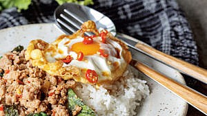a plate filled with ground beef, rice and a fried egg.