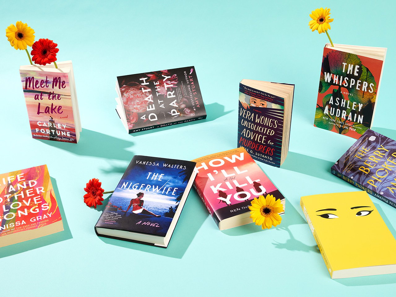 A photo of eight books spread across a light turquoise background and interspersed with yellow ad orange gerbera daisies.