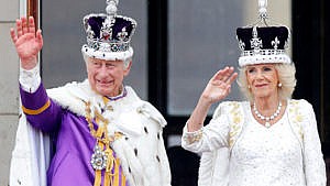 King Charles III and Queen Camilla wave from the balcony of Buckingham Palace, whilst watching an RAF flypast, following their coronation at Westminster Abbey on May 6, 2023 in London, England.