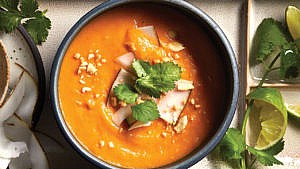 Thai sweet potato red curry soup in a bowl sprinkled with cilantro and coconut