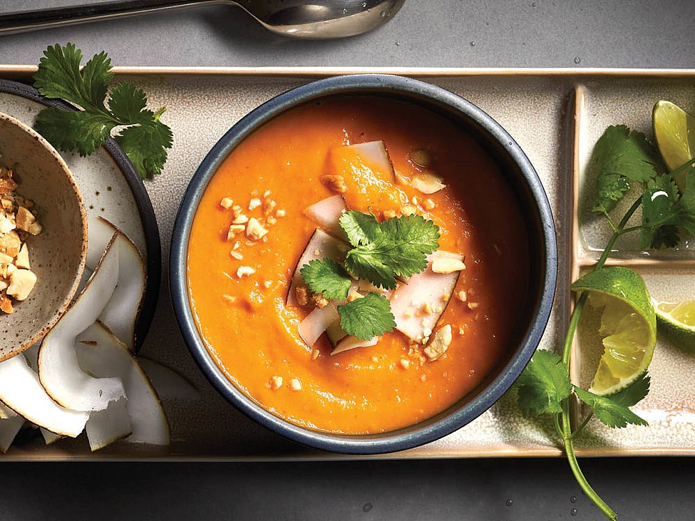 Thai sweet potato red curry soup in a bowl sprinkled with cilantro and coconut