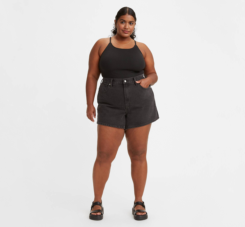 A model wearing black plus-size denim shorts from Levi's.