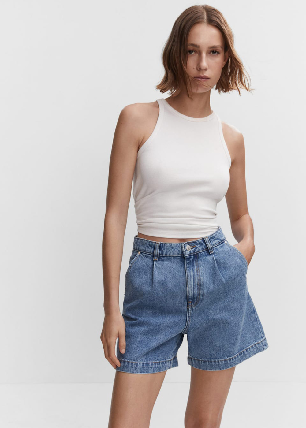 A model wearing tailored denim shorts from Mango.